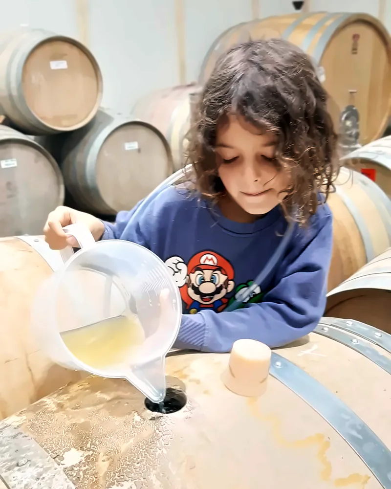 A child topping up a barrel